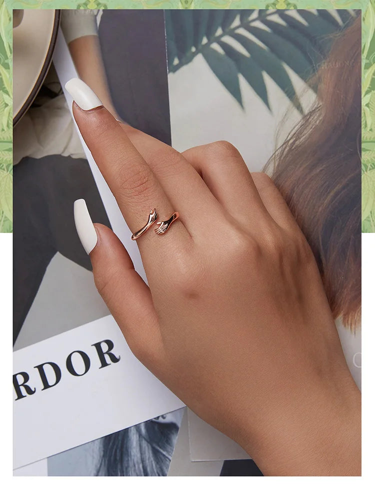 Anel Feminino BAMOER Abraço de Amor – Prata 925 Ajustável | Design de Mãos Entrelaçadas – 3 Cores Elegantes"