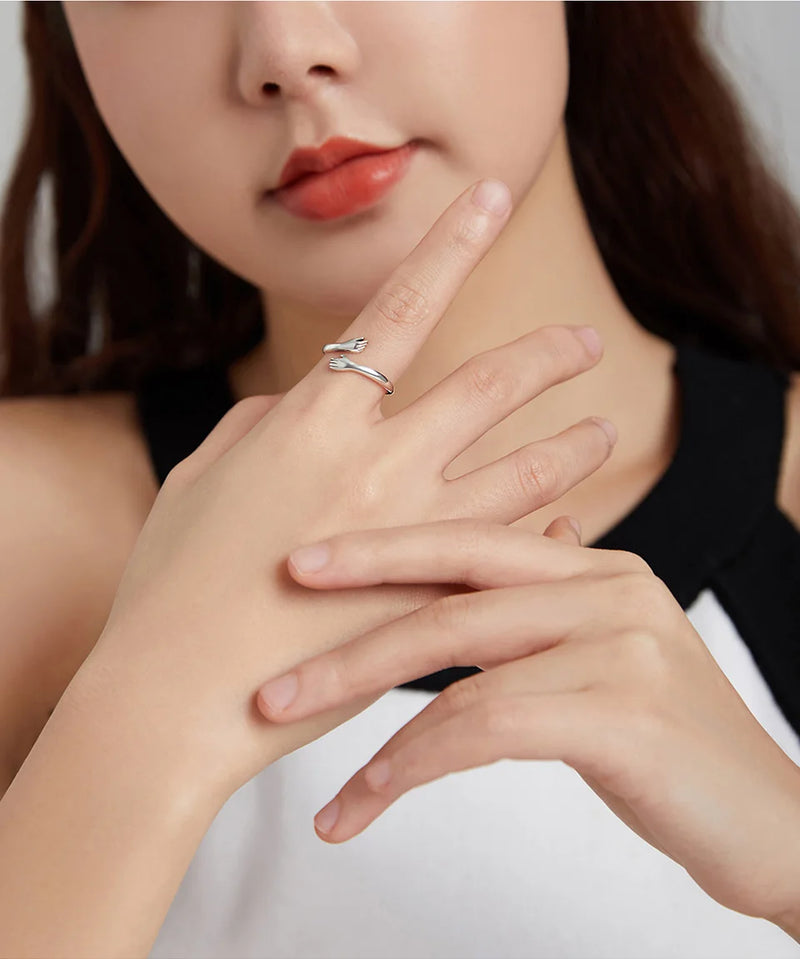 Anel Feminino BAMOER Abraço de Amor – Prata 925 Ajustável | Design de Mãos Entrelaçadas – 3 Cores Elegantes"